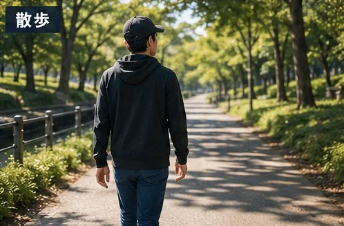 緑の並木道を散歩する男性